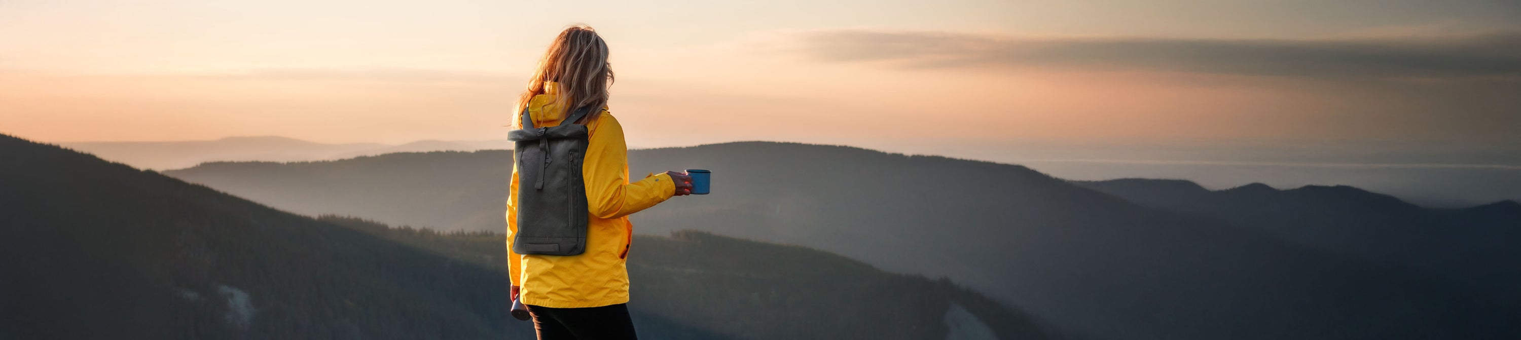 woman hiking wearing a grey calla backpack